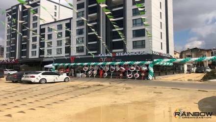 Bursa'da düzenlenen, profesyonel bir firma açılış organizasyonu anı. Şık dekorasyon ve kalabalık bir kutlama ortamı.